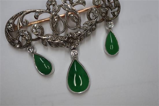 A 1920s yellow metal, diamond and jadeite set drop openwork scroll brooch, width 38mm.